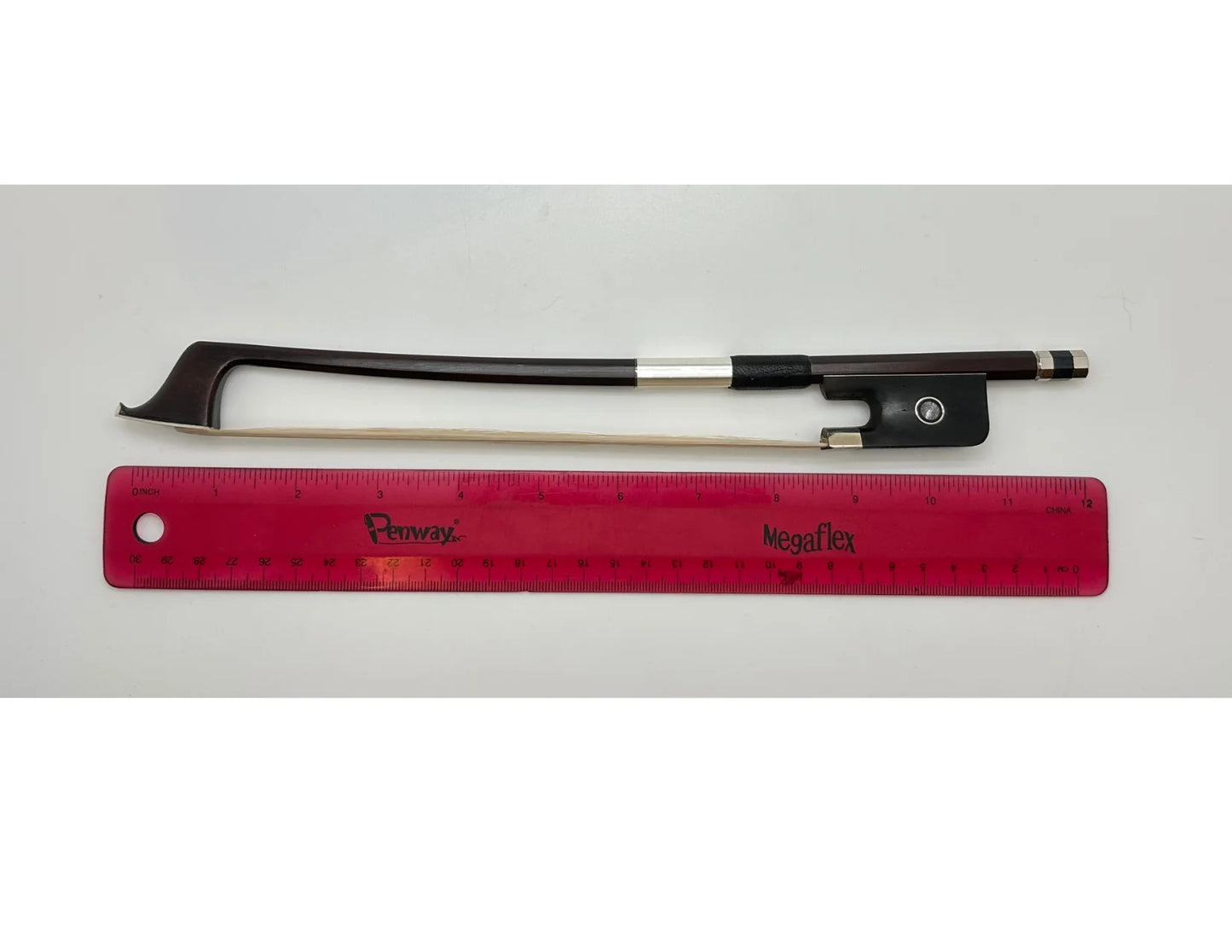 Violin bow and red ruler on a gray background